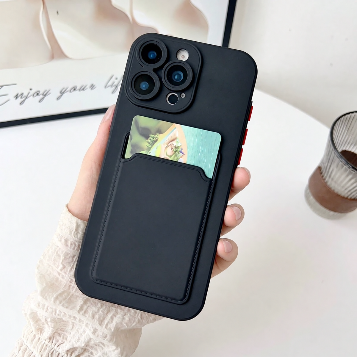 Black card slot phone case held upright with an example card in the rear pocket