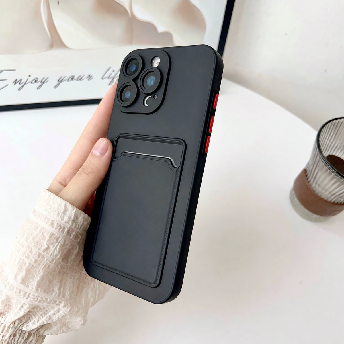 Black card slot phone case held upright showing the textured rear design and contrasting buttons