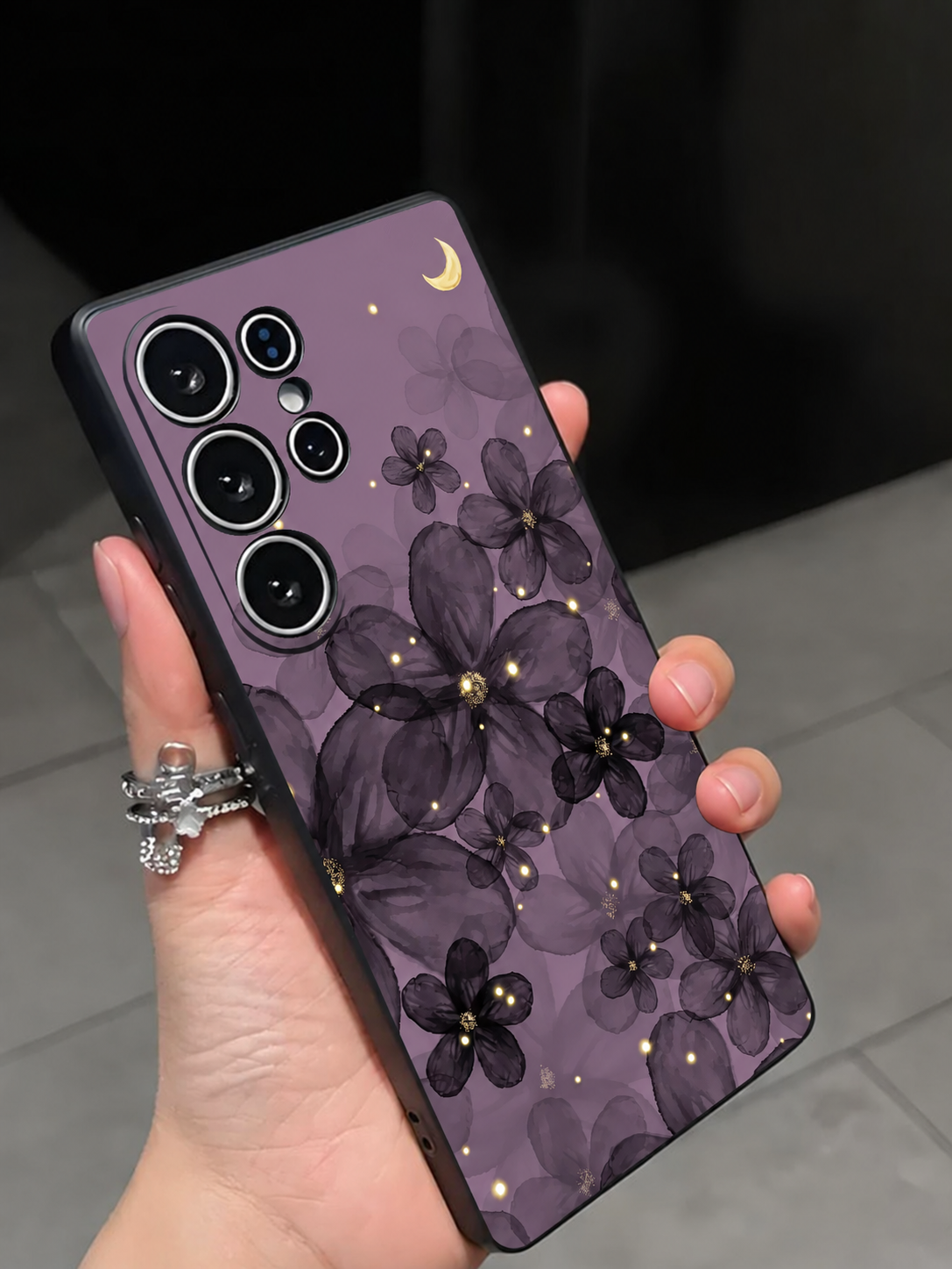 Purple floral moon phone case shown in hand with short natural nails
